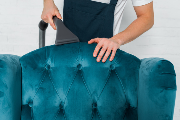 cropped view of cleaner dry cleaning blue modern armchair with vacuum cleaner  - Фото, изображение