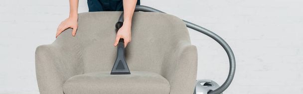 panoramiczne ujęcie młodego fotela czyszczącego na sucho z nowoczesnym odkurzaczem  - Zdjęcie, obraz