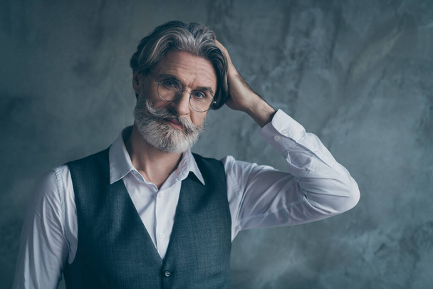Portrait of stunning confident cool macho old man millionaire look good mirror touch his silky haircut he prepare for meeting isolated over concrete wall grey color background - Foto, Imagen