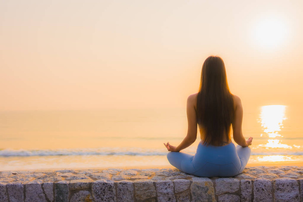 Portrait jeune femme asiatique faire méditation autour de la mer plage océan au lever du soleil pour la santé - Photo, image