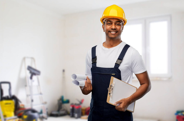 happy indian builder with blueprint and clipboard - Foto, imagen