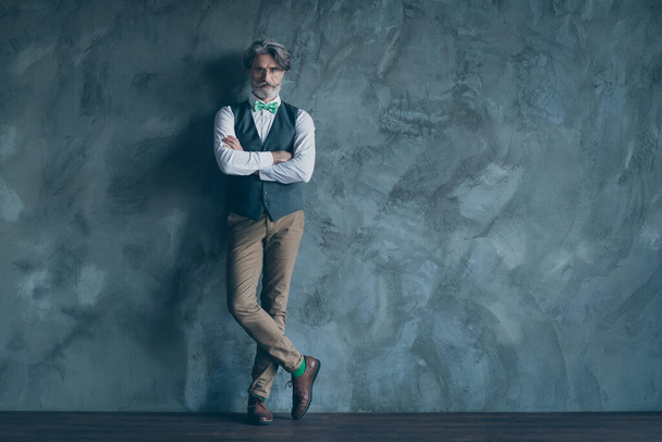 Full size photo of macho senior business man neat beard seriously look arms crossed wear specs shirt waistcoat pants green tie socks shoes isolated concrete grey color wall background - Φωτογραφία, εικόνα
