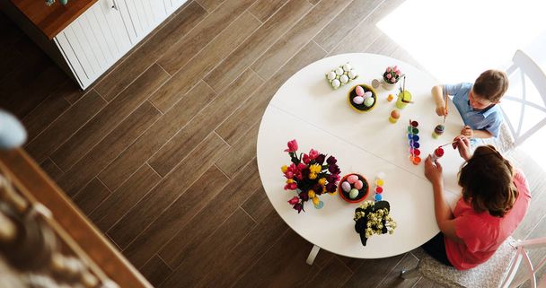 Happy Family Painting Easter Eggs On Kitchen Table - Φωτογραφία, εικόνα