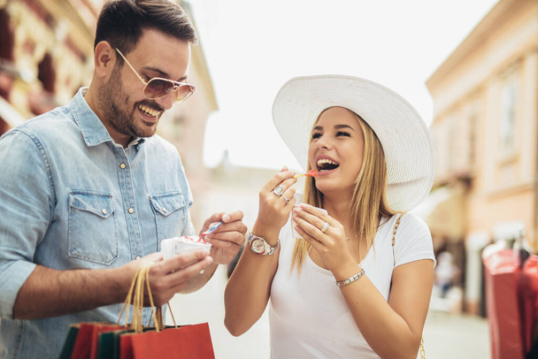 Couple souriant dans le shopping avec glace et sacs à provisions
  - Photo, image