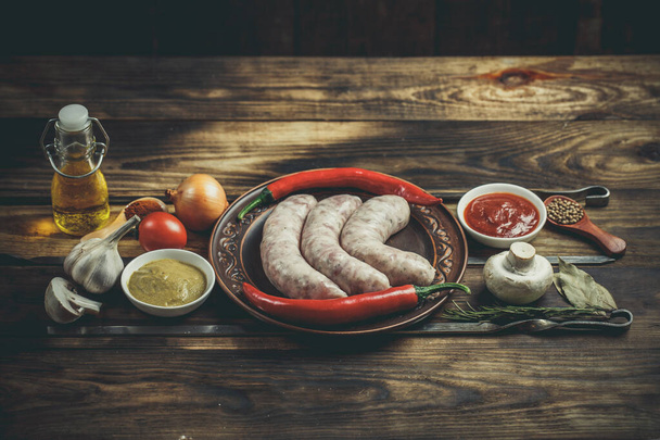 Many different spices, vegetables and ingredients, and fresh raw barbecue sausages for the family. - 写真・画像