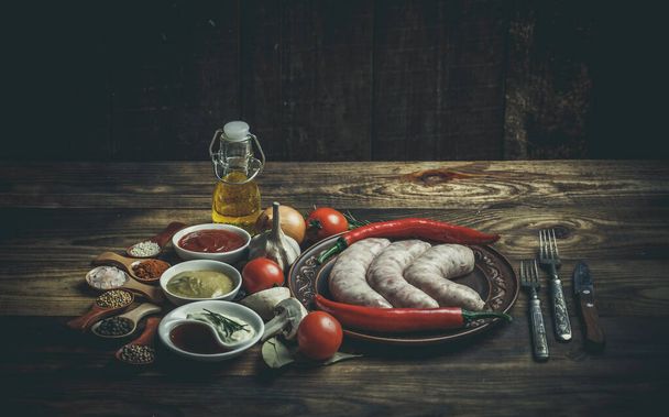Many different spices, vegetables and ingredients, and fresh raw barbecue sausages for the family. - Φωτογραφία, εικόνα