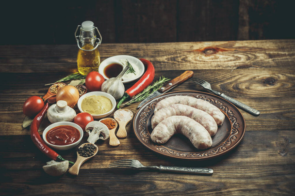 Many different spices, vegetables and ingredients, and fresh raw barbecue sausages for the family. - Φωτογραφία, εικόνα