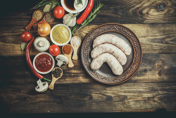 Many different spices, vegetables and ingredients, and fresh raw barbecue sausages for the family. - Photo, Image