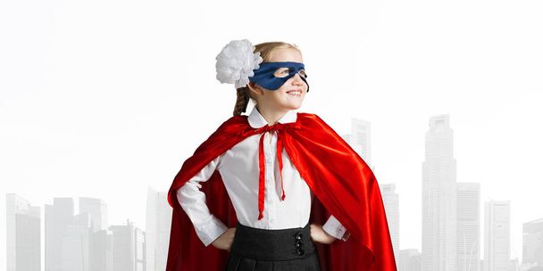 Małe dziecko pewnie w maskę i pelerynę gra fajne superbohatera - Zdjęcie, obraz
