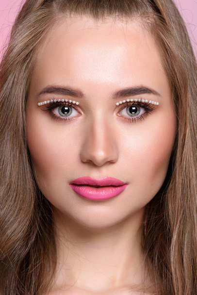 Beautiful girl with pearls make-up, pink lips. Long blond hair - Фото, изображение