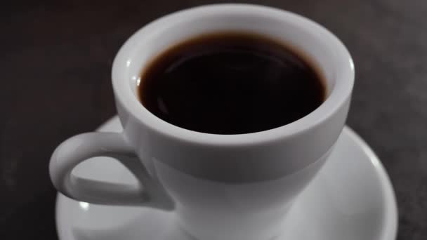 Een druppel valt langzaam in koffie in een kopje - Video