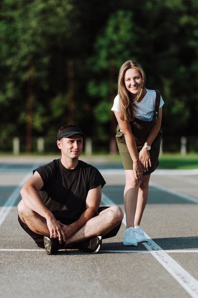 Un tipo está sentado en una cinta de correr, y su novia está a su lado
 - Foto, imagen