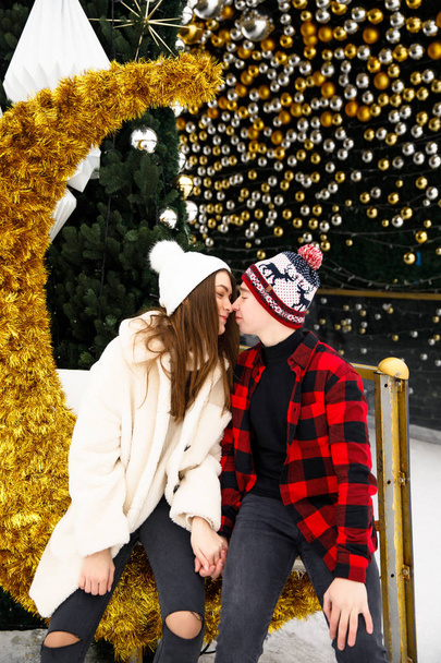 happy couple of lovers kissing on city skating rink and Christmas tree background - Foto, Imagem