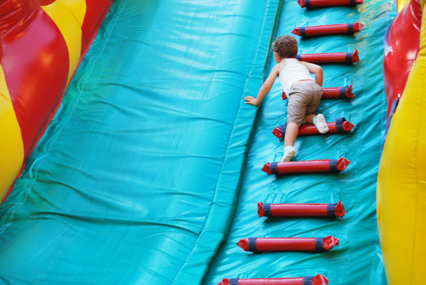 Little boy playing on an inflatable playground - Photo, Image