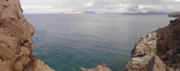 Blick vom Leuchtturm Akrotiri auf die Caldera, die Berge, das Mittelmeer und die Stadt Fira. - Foto, Bild