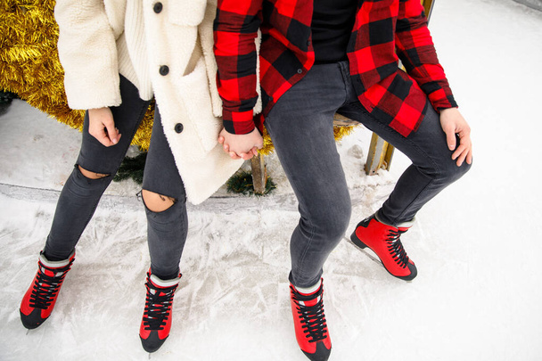 close up of boy and girl legs in skates on ice rink background - Foto, Bild