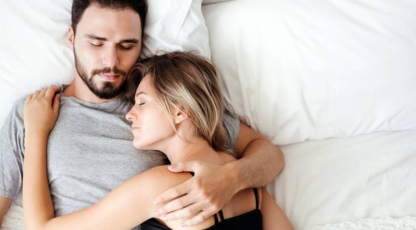 Couple sleeping on the bed in the morning loving couple in bedroom. - Photo, Image