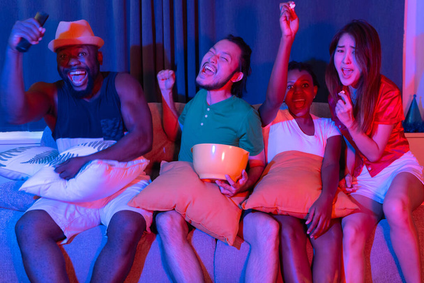 Grupo de amigos divirtiéndose en casa viendo fútbol y películas en la televisión. disfrutando y celebrando juntos
 - Foto, imagen