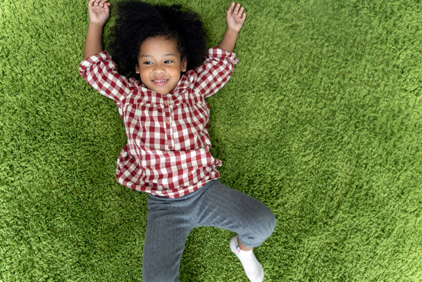 Happy children kids smiling and laying on green carpet floor in living room at home. - Foto, Bild