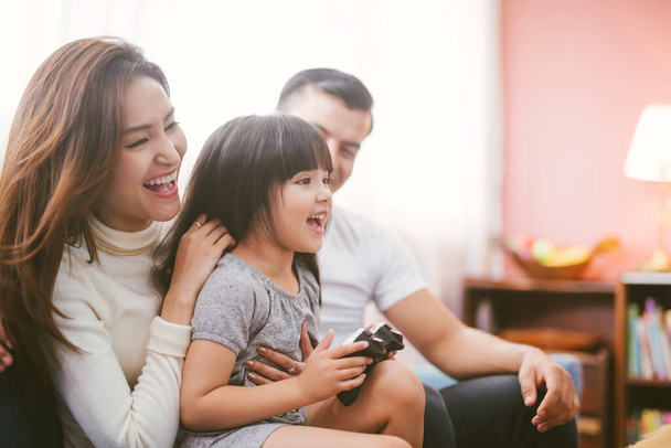 little girl and parent family playing video game at home - Φωτογραφία, εικόνα