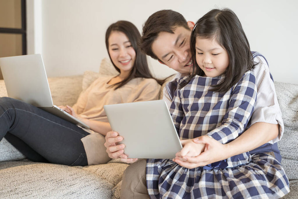 happy asian family spending time together on sofa in living room. family and home concept - Φωτογραφία, εικόνα