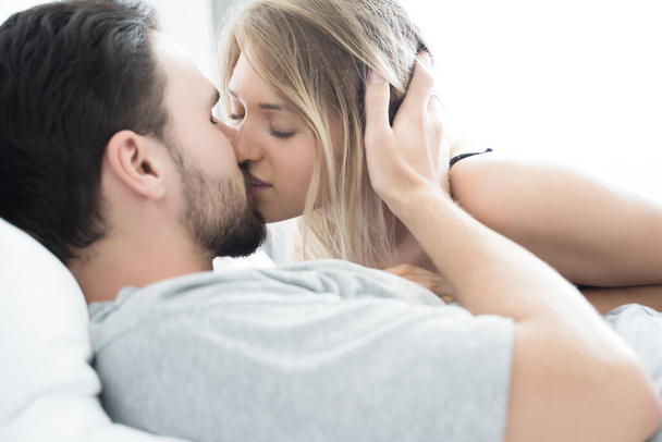 Young couple kissing in the bed .loving couple in bedroom - Foto, Bild