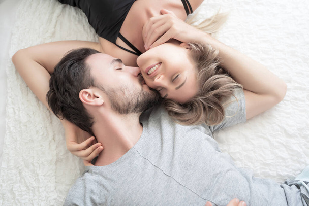 Young couple kissing in the bed .loving couple in bedroom - Фото, зображення