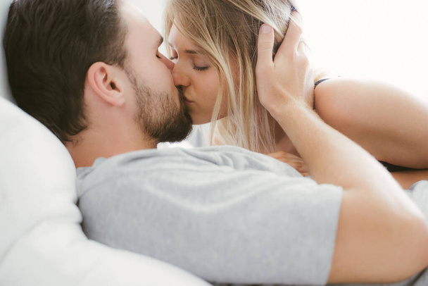 Pareja joven besándose en la cama .loving pareja en el dormitorio
 - Foto, imagen