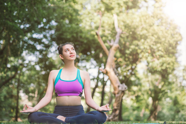 Yoga in the park healthy exercise. woman do lotus yoga pose - Zdjęcie, obraz