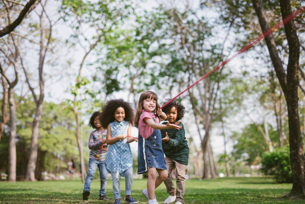 Group of children playing tug of war at the park. - Φωτογραφία, εικόνα