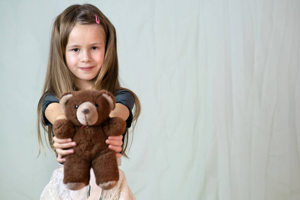 Pretty child girl playing with her teddy bear toy. - Foto, afbeelding