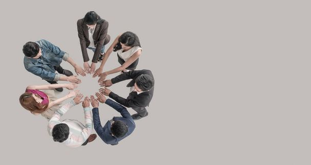 Верхний взгляд на людей в командных руках в кругу вместе, как на единство и командную работу в офисе. сотрудничество молодых азиатских команд и групп
 - Фото, изображение