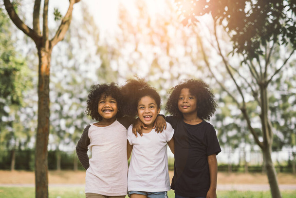 Children Friendship Togetherness Smiling Happiness Concept.Cute african american little boy and girl hug each other in summer sunny day - Photo, Image
