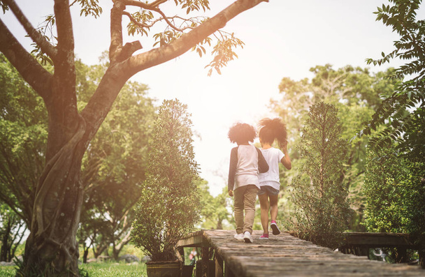 Lasten ystävyys Togetherness käsite. Afrikkalainen amerikkalainen pieni poika ja tyttö halata toisiaan kesällä aurinkoinen päivä takaisin näkymä
 - Valokuva, kuva