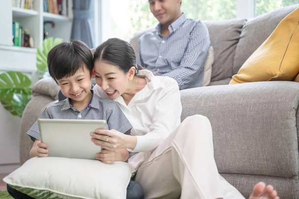 happy asian family spending time together on sofa in living room. family and home concept - 写真・画像