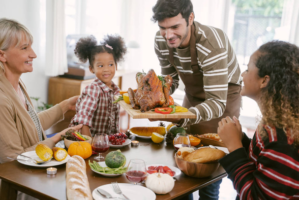 Onnellinen perhe juhlimassa kiitospäivän ateriaa kotona. Juhlaperinne käsite
 - Valokuva, kuva