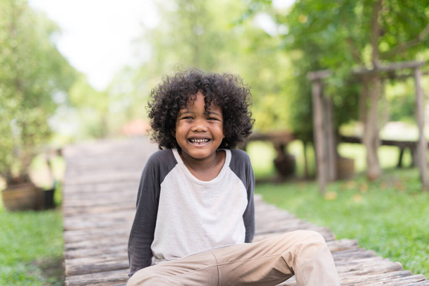 портрет милого африканского мальчика, улыбающегося в природном парке
. - Фото, изображение