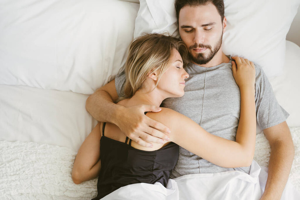 Young couple sleeping on the bed in the morning. loving couple in bedroom - Foto, imagen