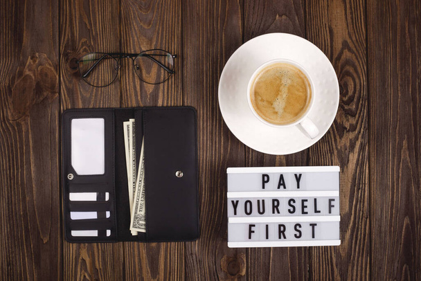 Pay yourself first. Personal finance concept. Leather wallet on a wooden table. - Fotoğraf, Görsel