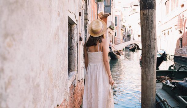 Young woman travel Italy. Vacation in Europe. Girl enjoy beautiful view in Venice. Female tourist walking on streets in Venezia. Fashion blogger take photo on scenic bridge of Grand Canal. - Фото, изображение