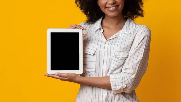 Digitale tablet met zwart scherm in handen van onherkenbare Afro vrouw - Foto, afbeelding