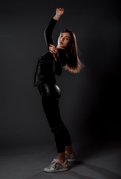 Elegante jovem mulher vestindo calças de couro preto e casaco preto
 - Foto, Imagem