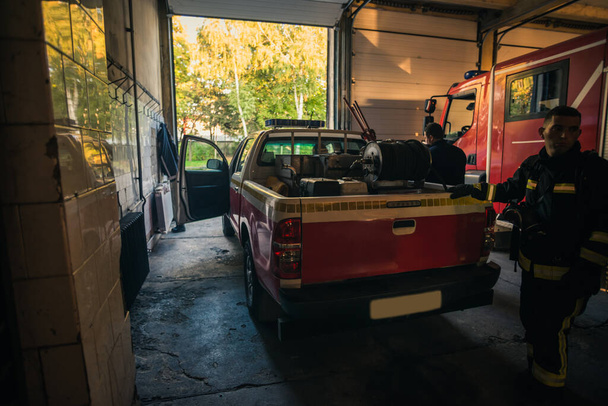Вантажівка пожежного двигуна припаркована всередині гаража пожежного відділення
 - Фото, зображення