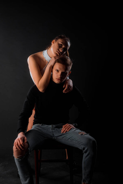Sensual loving man and woman posing against a black background - 写真・画像