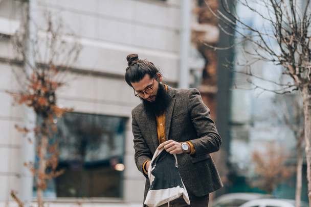 Komea luottavainen mies pukeutunut moderniin tyyliin vaatteita kaupunkiympäristössä - Valokuva, kuva