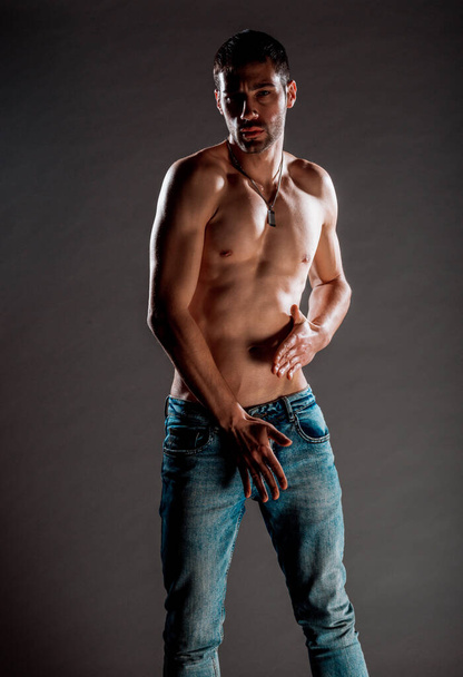 Torso shot van een coole shirtloze man in trendy blauwe jeans - Foto, afbeelding