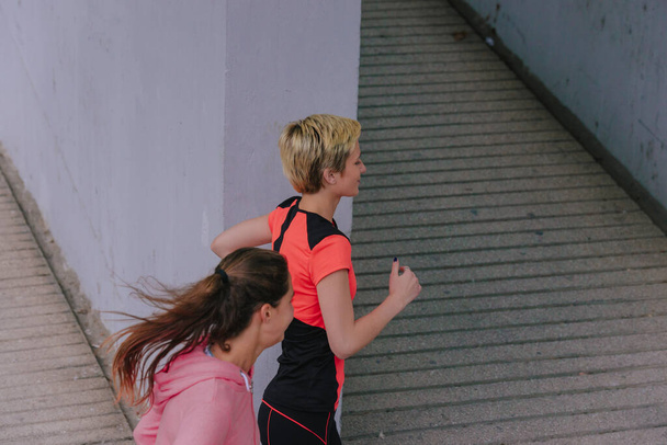 Jovens corredoras saudáveis durante uma rotina de exercícios urbanos
 - Foto, Imagem