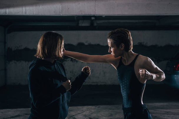 Foto silhouette di due giovani donne che si esercitano a combattere all'interno del garage. - Foto, immagini