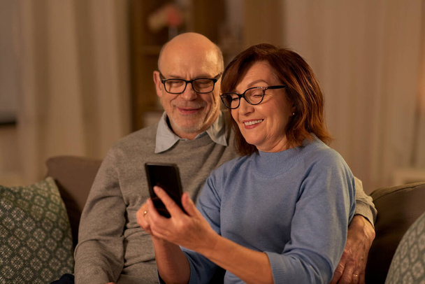 happy senior couple with smartphone at home - Foto, afbeelding