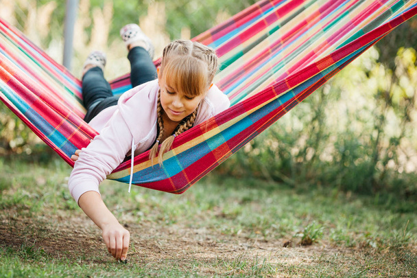 tiener meisje liggend in kleurrijke vrijetijdsbesteding hangmat - Foto, afbeelding
